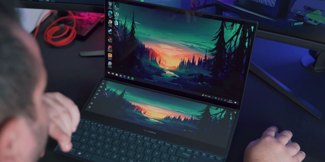 Ein Laptop mit zwei Bildschirmen, der intensive Tapetengrafiken zeigt.