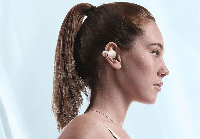 Mujer usando auriculares clip-on.